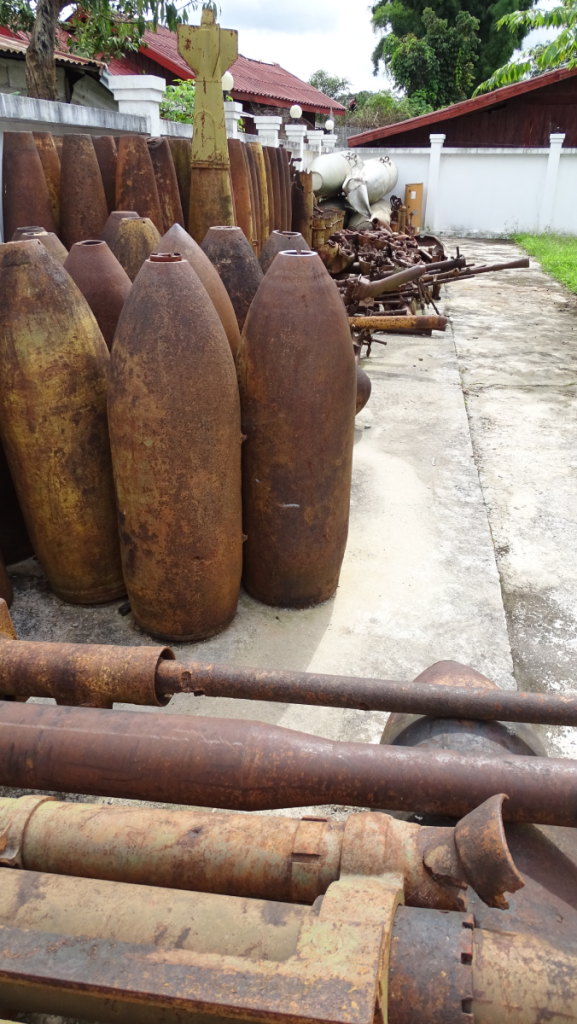 A backyard filled with rusty shells of bombs and other weapon from the Vietnam War times