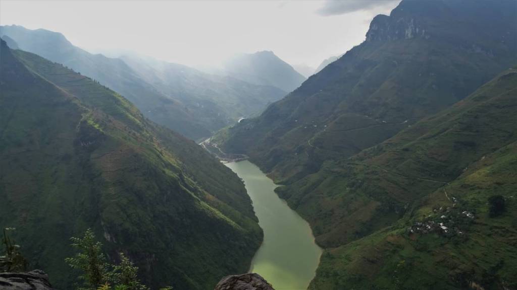 The viewpoint at Ma Pi Leng pass: a river on the bottom of a deep canyon between high, green mountains