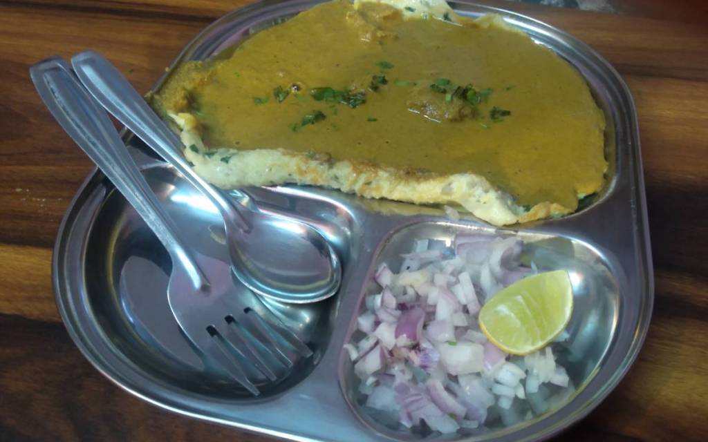 Steel plate with Goan ras omellete, served with chicken curry and raw onion